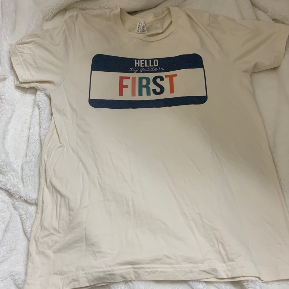 Bella canvas size large cream tshirt. Shirt says “Hello my grade is first”